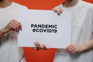 people holding white paper with pandemic covid19 text 3952234